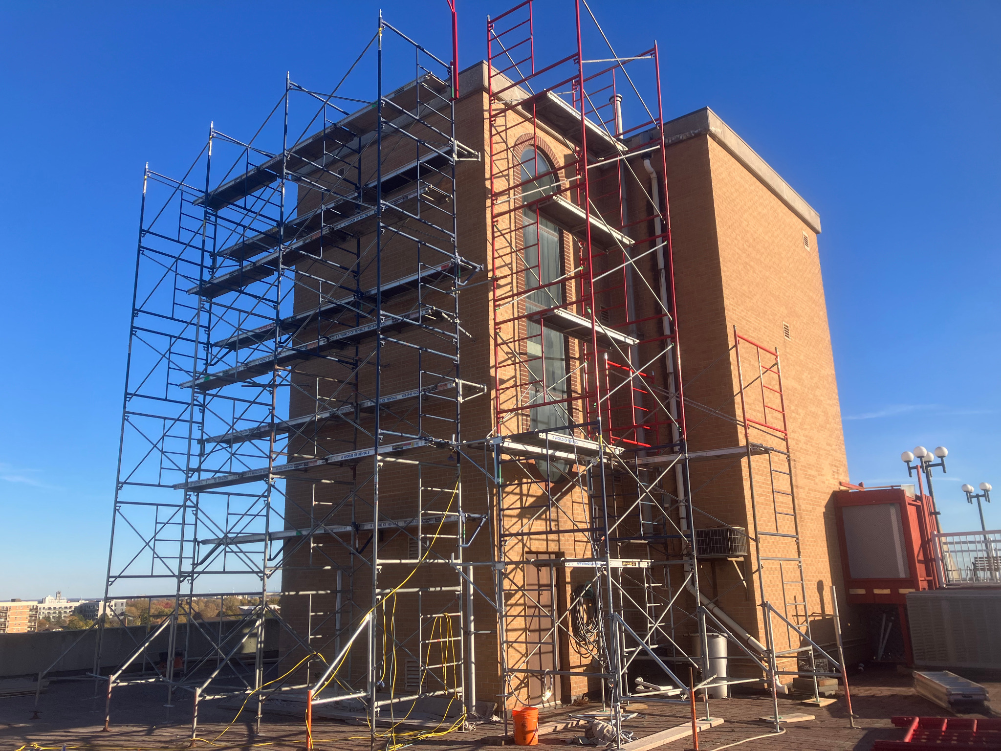 Large commercial brick building surrounded by full-height restoration scaffolding
