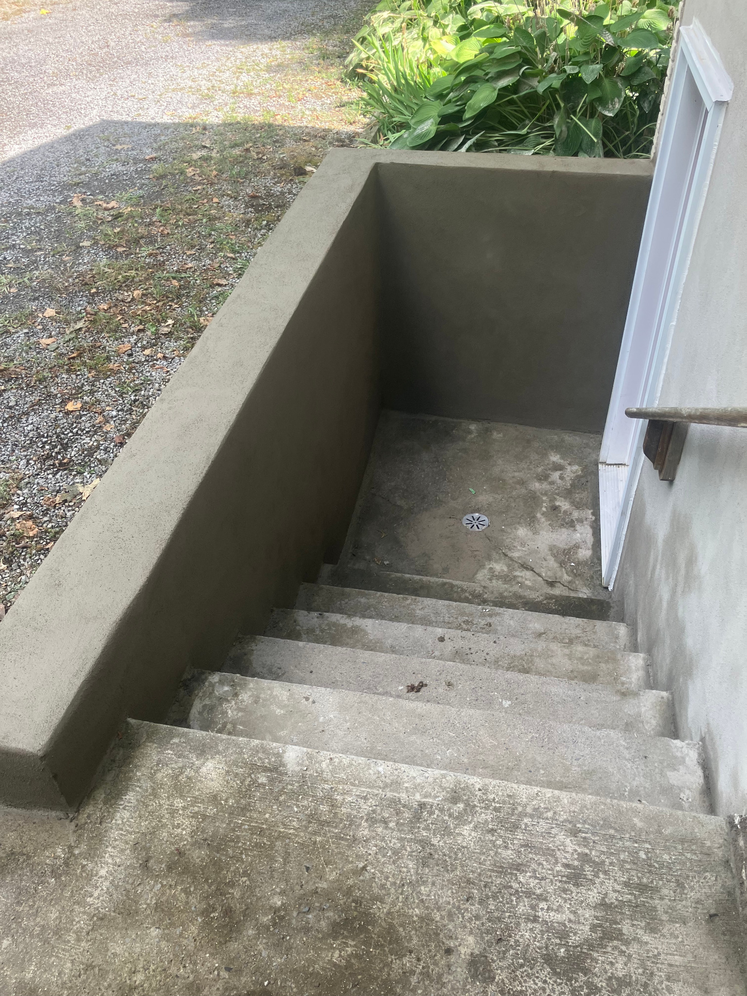 Smooth parged finish on an exterior basement entrance wall