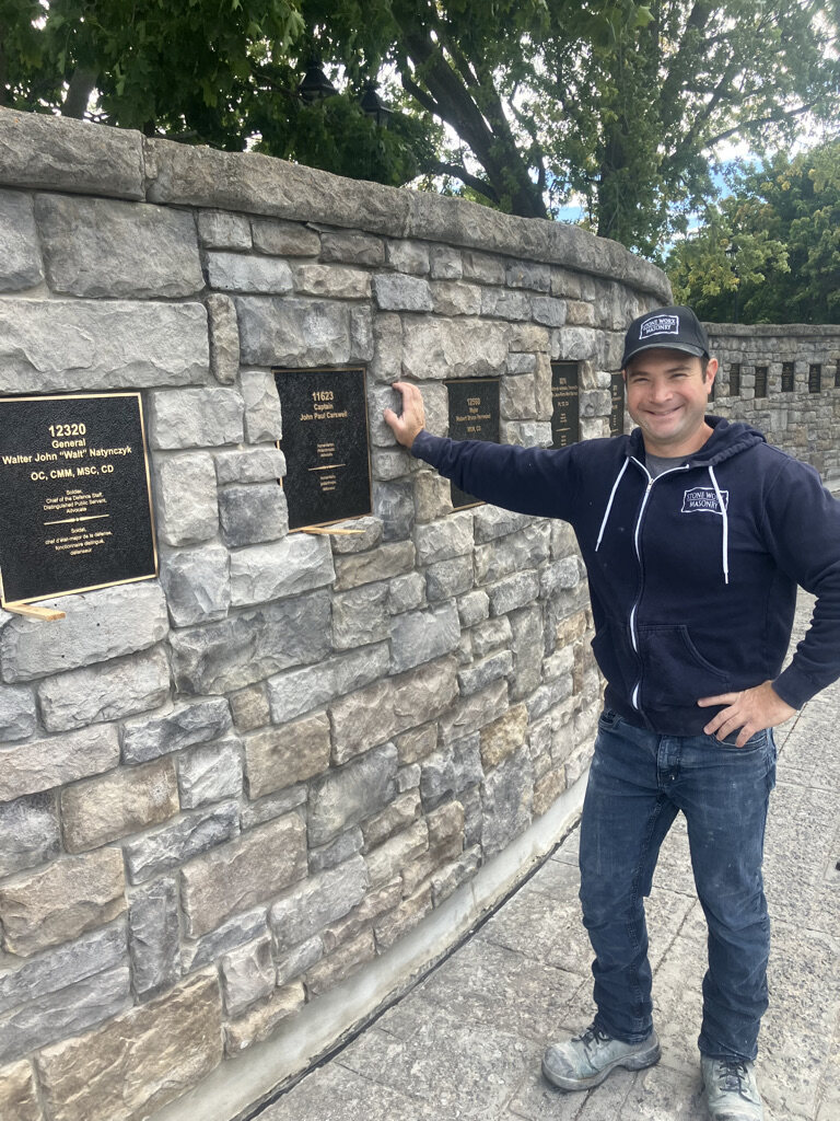 Stone Worx founder and lead mason Lee Rankin beside a local Wall of Honour